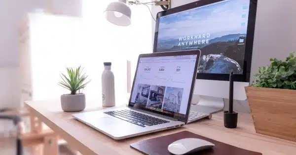 MacBook Pro on table beside white iMac and Magic Mouse