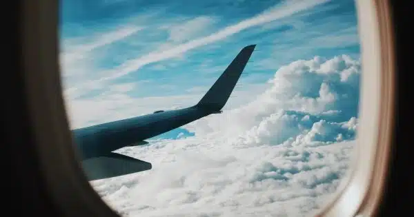 person taking picture of plane wings while flying during daytime