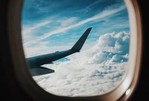 person taking picture of plane wings while flying during daytime