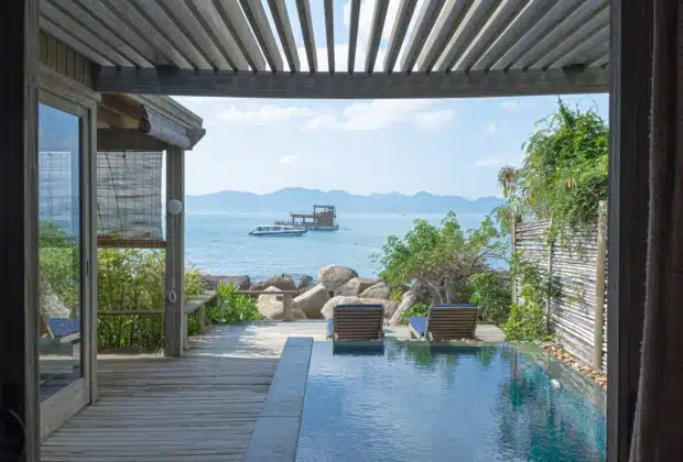 brown wooden chairs near swimming pool during daytime